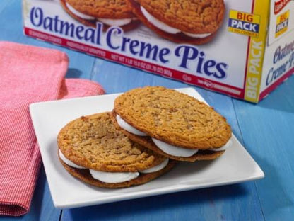 Little Debbie Oatmeal Creme Pies on a plate beside the Big Pack box.